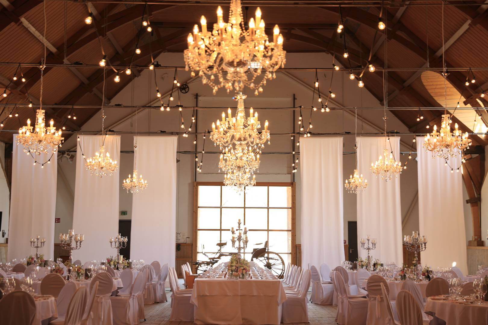 Hochzeitsdekoration mit Mobiliar in der Reithalle von Gut Sonnenhausen von Eventdecor